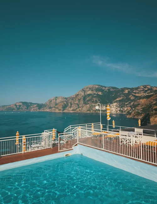 Piscina sul tetto con vista panoramica sulla costa e le montagne.