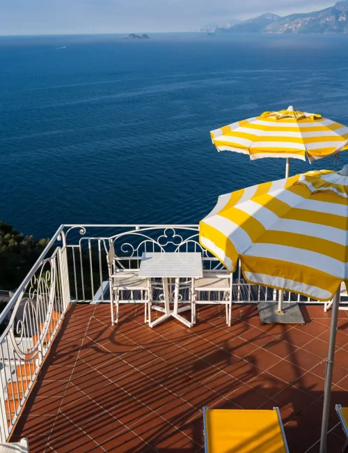Terrazza con ombrelloni gialli e vista panoramica sul mare.